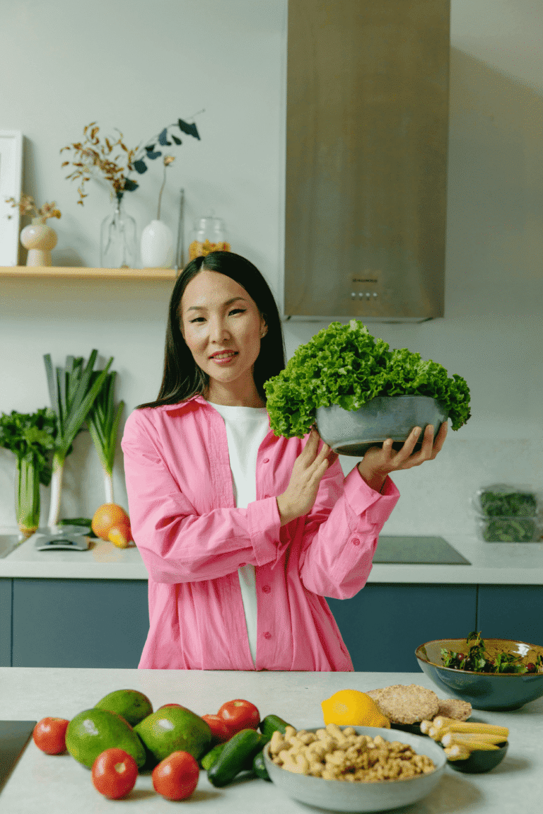 Smiling woman over 40 holding a bowl of fresh lettuce for gut health support